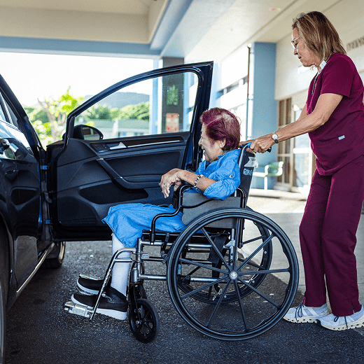 Caregiver helping senior into vehicle