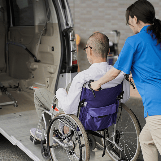 Person helping wheelchair user into vehicle